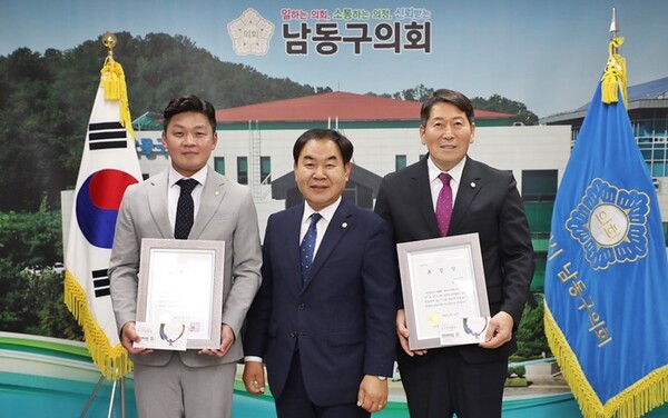 ·▲오용환 (중앙)의장이 우수의원으로 선정된 김재남(왼쪽)·전용호 의원과 기념사진을 찍고 있다.